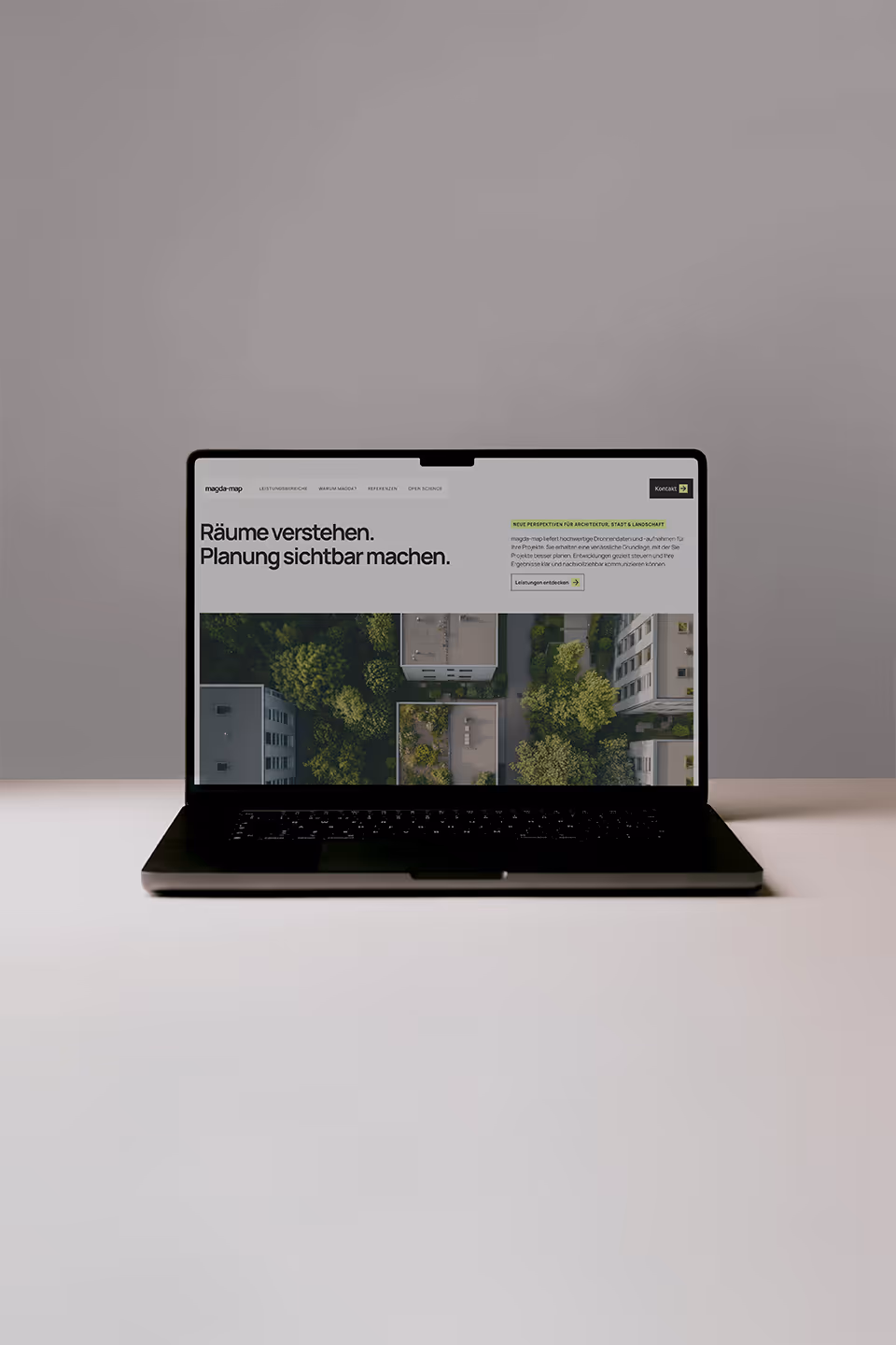 magda-map website homepage displayed on a laptop showing aerial imagery and spatial data for urban planning and landscape analysis